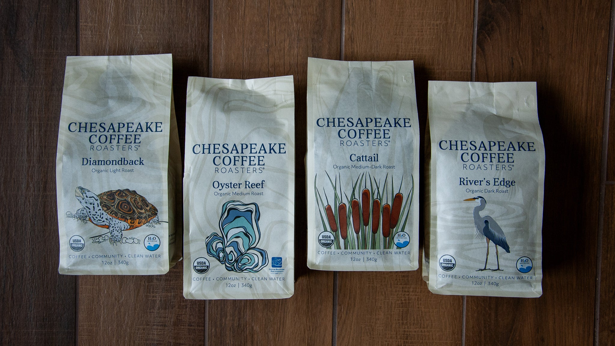 Four bags of Chesapeake Coffee Roasters on a wooden surface